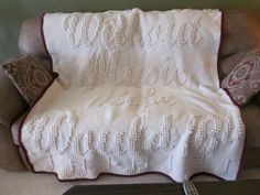 a white crocheted blanket sitting on top of a couch