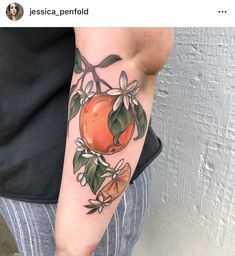 an orange with leaves and flowers on the arm