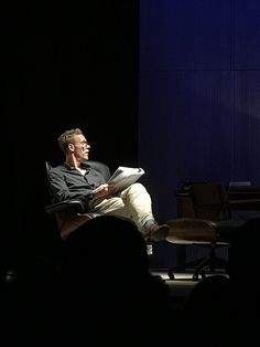 a man sitting in a chair reading a book