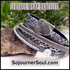 the leather wrap bracelet is on top of a rock and sits next to some leaves