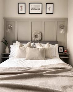 a bed with pillows and pictures on the wall above it