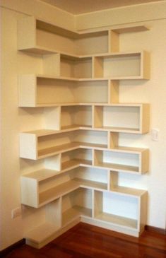 an empty room with shelves on the wall and hard wood flooring in front of it