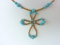 a necklace with blue beads and a cross on it