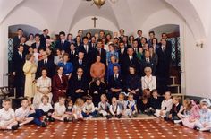 a large group of people in suits and ties are posing for a photo on the floor