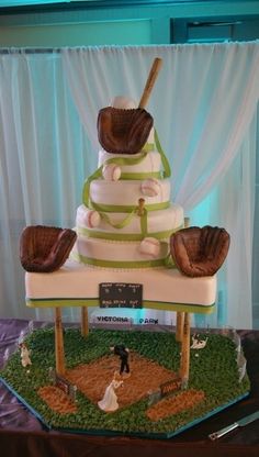 a wedding cake made to look like a baseball field with glove on top and bride and groom in the middle