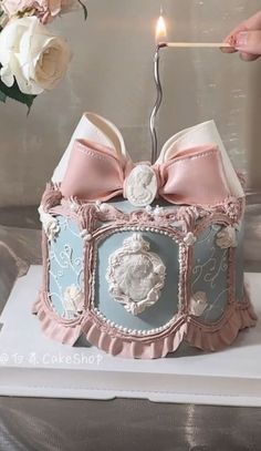 a cake that is shaped like a box with a candle in it