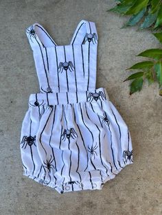 This beautiful pinafore bloomer romper is the perfect unisex garment! It's extremely versatile with easy diaper access with snaps, and can be styled in so many ways! Wear it as is in warm weather or layered with long sleeve shirts and cute socks or tights in cooler weather. It is super soft and comfortable for your little, featuring adjustable straps and an elastic waistband so it will grow as your child does. 100% Cotton Flannel Wash on Delicate Cycle Dry on Low or Lay Flat to Dry Cute Bib Front Overalls For Summer, Playful White Overalls For Summer, Summer Cotton Bubble Romper With Bib Front, Cute Cotton Bubble Romper With Buttons, Cute White Cotton Overalls, Cute Cotton Halloween Onesie, Gothic Baby Clothes, Alternative Baby Clothes, Goth Baby Clothes