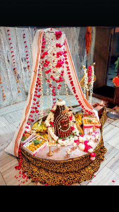 a decorated bed sitting on top of a wooden floor next to a wall covered in flowers