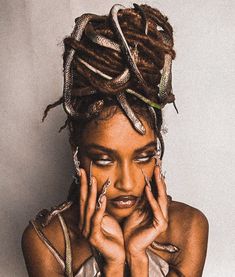 a woman with dreadlocks on her head and hands in front of her face