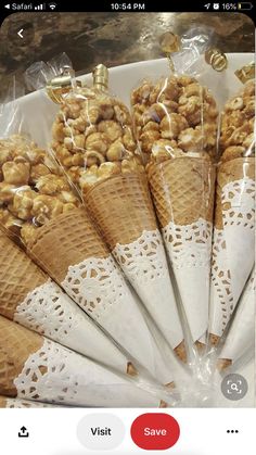 ice cream cones filled with nuts on top of a white plate in front of a counter