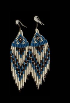 two pairs of beaded earrings with white and blue beads on black background, one is hanging