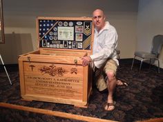 a man sitting on the floor next to an old fashioned wooden box with information and symbols