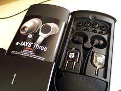 an open box with earphones in it on a table next to a pair of headphones