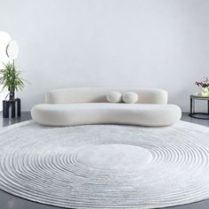 a white couch sitting on top of a round rug