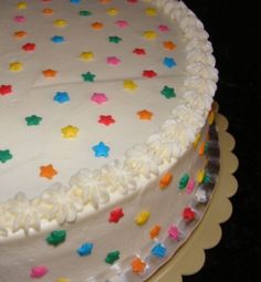 a cake with white frosting and multicolored stars on it