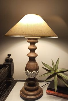 a lamp sitting on top of a table next to a plant