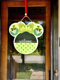 a welcome sign hanging from the front door of a house with a mickey mouse head on it