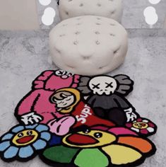 a white chair sitting on top of a floor next to a rug covered in cartoon characters