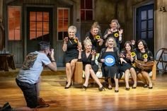 a group of women sitting on top of a wooden floor next to each other in front of a man