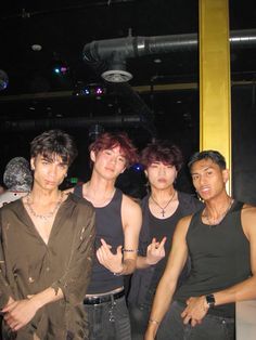 four young men posing for the camera at a party