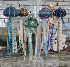 there are many different types of beads on this display stand with ribbons attached to them