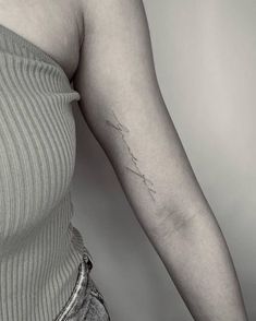 a woman's arm with a small tattoo on the left side of her arm