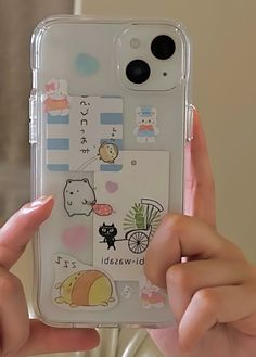 someone holding up their phone case with stickers on it