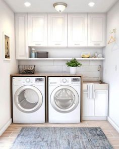 a washer and dryer in a white laundry room with blue rug on the floor