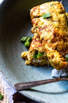 an omelet on a plate with chopsticks next to it