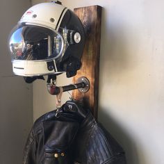 a motorcycle helmet and leather jacket hanging on a wall