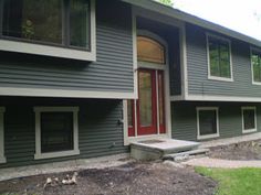 a house with green siding and red door