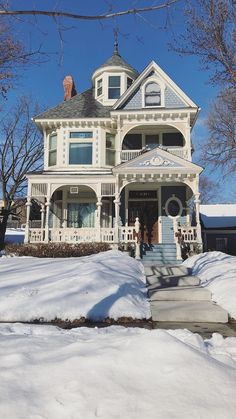 a large white house with snow on the ground and steps leading up to it's front door