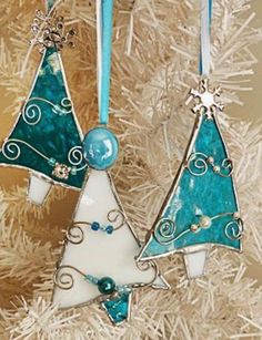 two ornaments hanging from a christmas tree with blue and white decorations on it's sides