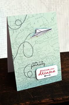 a close up of a small card with a paper airplane on the front and back