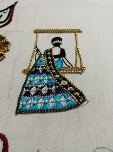 a close up of a piece of cloth with bead work on it and some beads