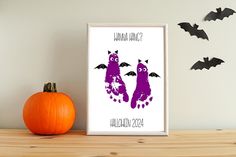 two purple bats are on the wall next to a pumpkin