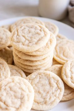 a white plate topped with cookies next to a glass of milk