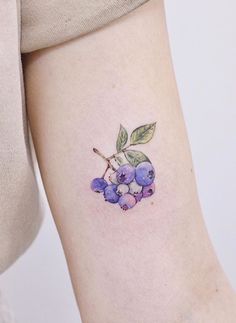 a small blueberry tattoo on the ankle