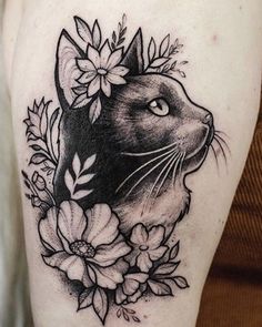 a black and white cat with flowers on its head is shown in this tattoo design