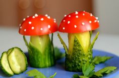 two small mushrooms are sitting on top of broccoli stalks and cucumbers