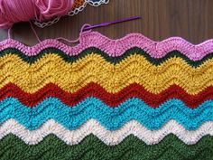 a crocheted blanket with yarn on top of it