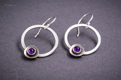 Amethyst drop earrings ideal for every occasion. Inspired from ancient Greek jewelry with a sparkle of purple Amethyst on the bottom you can wear it everyday, or on a special evening. These beautiful earrings are handmade on Sterling Silver 925. The Amethyst is 4mm diameter round Cabochon cut and set safe in a bezel. For any question, you may have, feel free to send me a message. Material: Sterling Silver 925 Gemstone: Precious Amethyst cabochon cut 4 mm diameter Finish: Shiny Width: 2,1 cm Leng Modern Purple Dangle Jewelry, Modern Purple Gemstone Earrings, Modern Amethyst Earrings As Gift, Modern Amethyst Gemstone Earrings, Purple Modern Sterling Silver Earrings, Modern Purple Sterling Silver Earrings, Modern Silver Earrings With Birthstone, Modern Silver Birthstone Earrings, Nickel-free Purple Earrings For Everyday