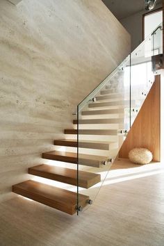 a staircase with glass railing and wooden steps