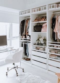 a white closet filled with lots of clothes and bags next to a computer monitor on top of a desk