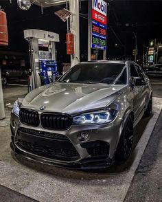 a silver car parked in front of a gas station