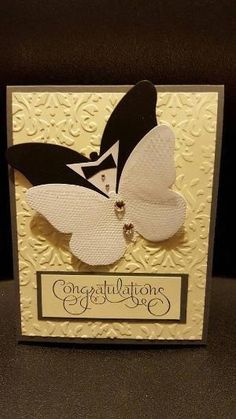 a white card with black and white butterfly on it's side, says congratulations