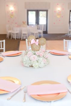 the table is set with pink and gold place settings