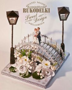 a wedding card with a bridge and flowers on the front, and two lights in the back