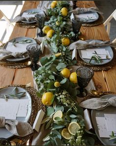 the table is set with lemons and greenery for an elegant dinner or party