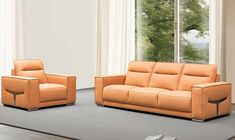 an orange leather couch and chair in front of a window with trees outside the window